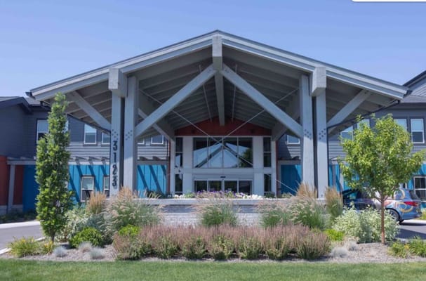 Modern entrance of senior living facility with landscaped garden