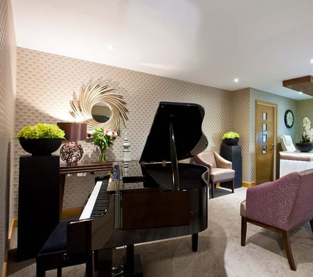 Elegantly designed lounge featuring a piano and comfortable seating.