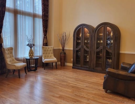 Bright living room with two chairs, a coffee table, and a display cabinet