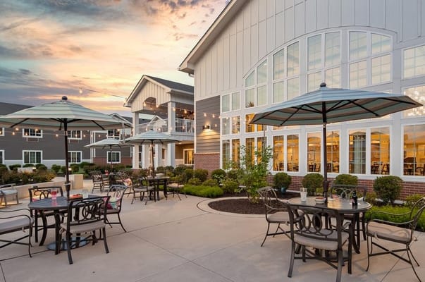 Patio area with tables and umbrellas at sunset