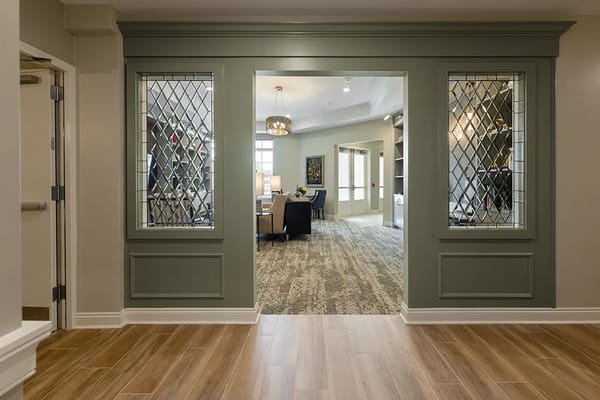 View of the lobby entrance with decorative glass panels and a carpeted area