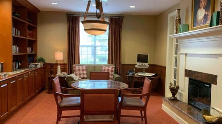 Lounge area with a table, chairs, and a bookshelf
