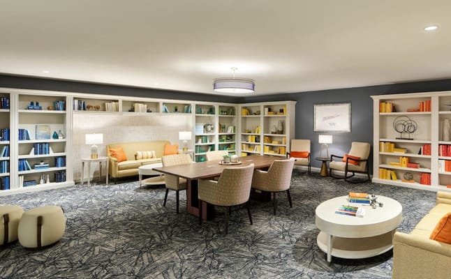 Bright and welcoming common area with bookshelves and comfortable seating