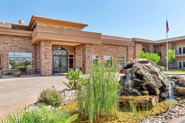 Main entrance with stone facade and water feature