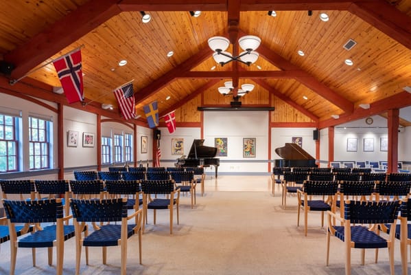 Empty performance hall with grand pianos and flags