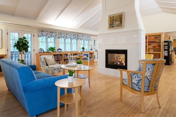 Comfortable living room area with blue and patterned chairs, a coffee table, and a fireplace.