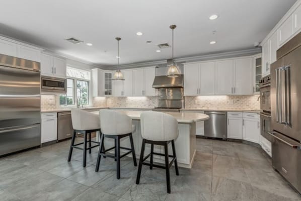 Bright, modern kitchen with island seating and stainless steel appliances