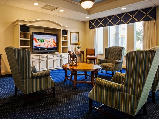 Welcoming lounge area with striped chairs and a television