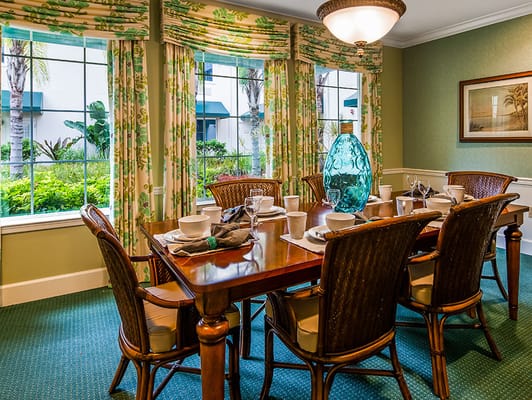 A beautifully set dining table in a well-lit room with large windows.