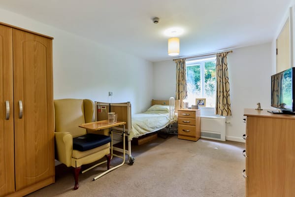 Spacious living area with a bed, chair, and storage unit