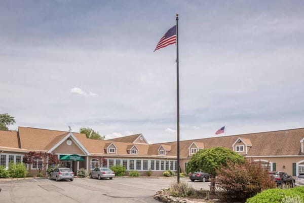 Front view of Tiffany Court at Kingston with cars parked and an American flag