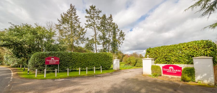 Entrance gate of Tithe Farm with hedges and trees