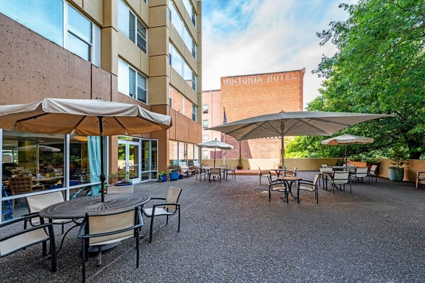 Patio area with tables and umbrellas outside Truewood by Merrill, First Hill.