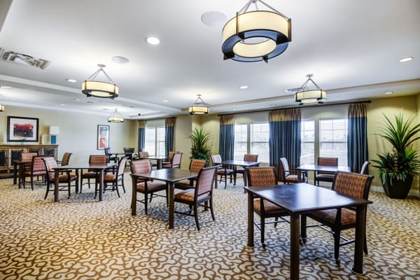 Bright dining area with tables and chairs at Truewood by Merrill
