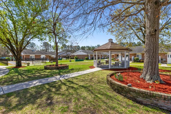 A peaceful outdoor area with a gazebo and green lawn