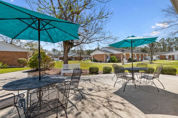 Outdoor seating area with umbrellas and landscaped garden