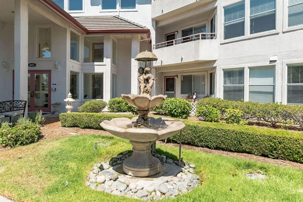 Stone fountain surrounded by greenery outside Truewood by Merrill