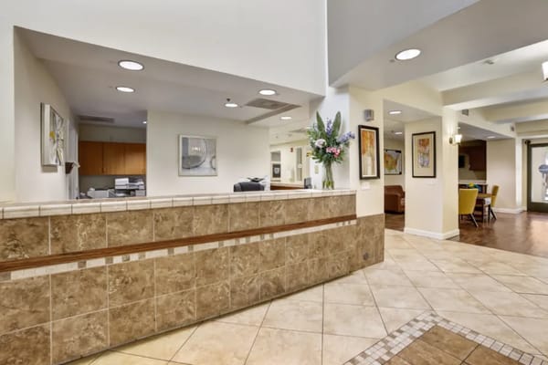 Welcoming reception area with a front desk and floral arrangements.
