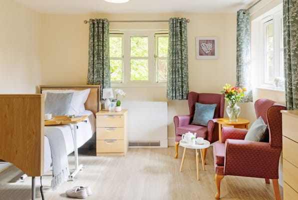 Brightly decorated senior living room with a bed and seating area