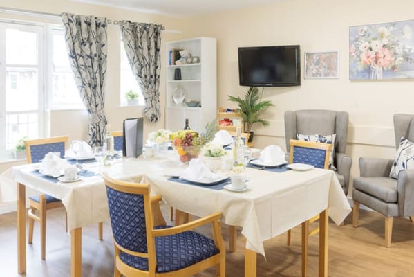 A cozy dining room with a table set for a meal and comfortable seating.