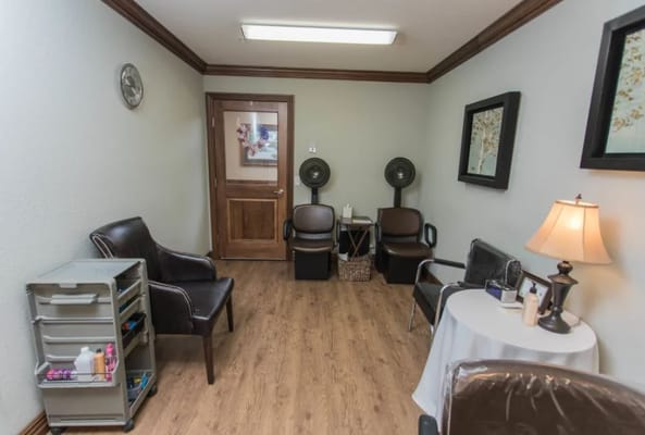 A salon room featuring chairs, a table, and decor.