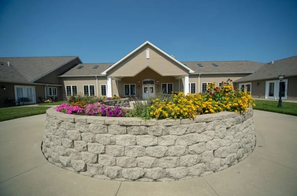 Facade of Villas of Holly Brook Herrin featuring colorful flower beds