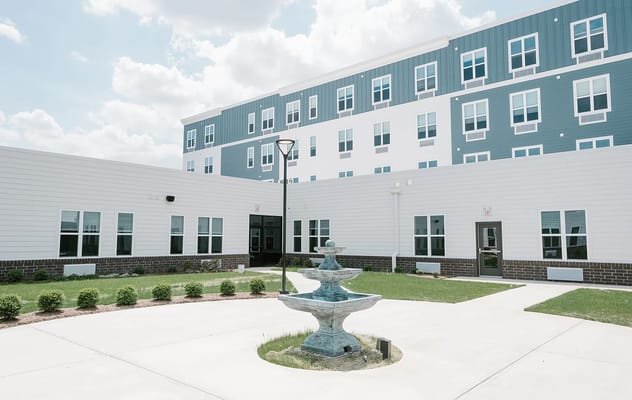 Exterior view of a senior living facility with a fountain