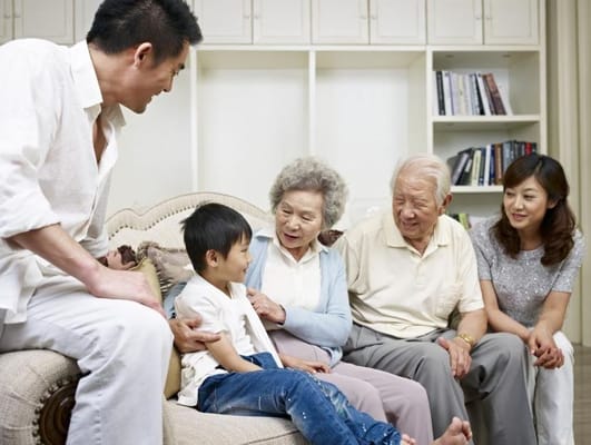 Family members interacting with seniors in a cozy living room
