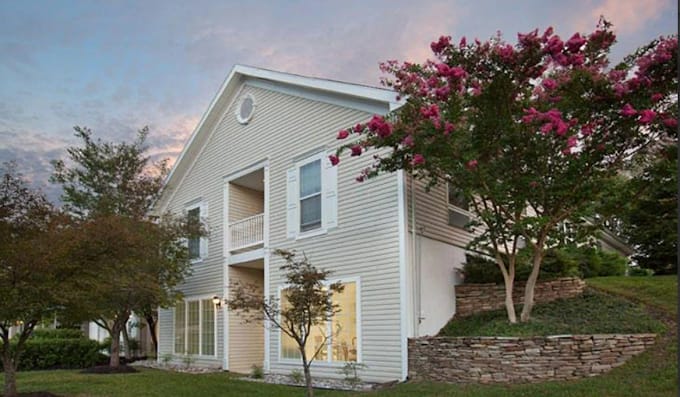 Exterior view of a residential building with trees and flowers