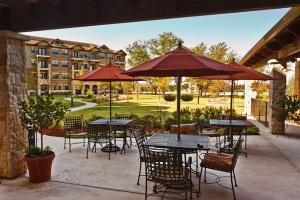 Patio area with umbrellas and seating overlooking a garden