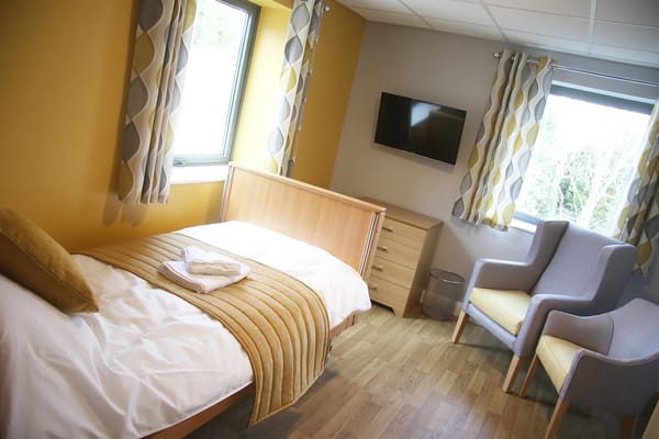 A private resident room with a bed and a chair