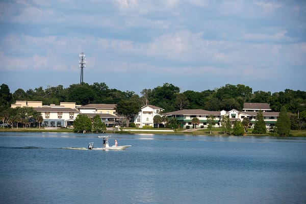 Residents paddleboarding on a calm lake by the facility