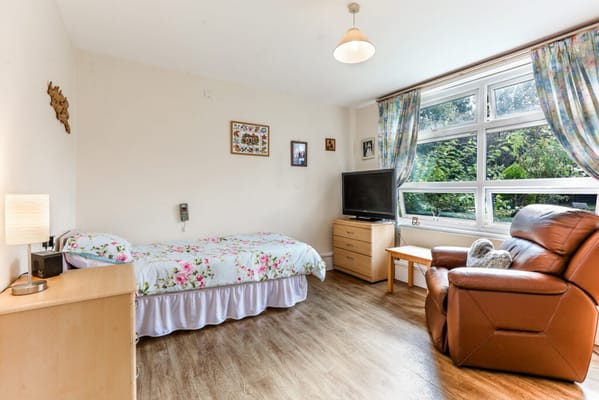 Private room with bed, chair, and TV