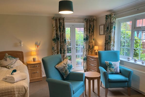 A cozy resident room with seating and natural light