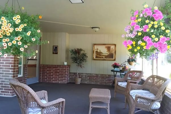 Cozy indoor common area with hanging flowers and wicker furniture