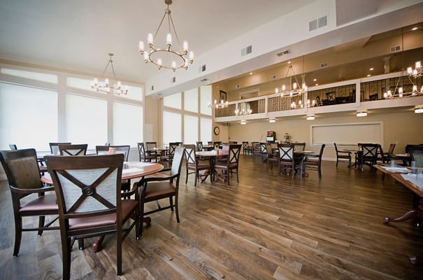 A spacious dining room with elegant lighting and furniture