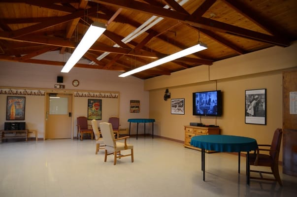 Spacious activity room with wooden beams and a TV.