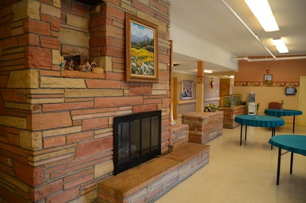 Lounge area featuring stone fireplace and tables