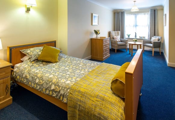 Comfortable bedroom with a bed, dresser, and seating area