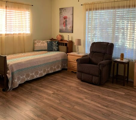 Comfortable resident room with a bed and armchair