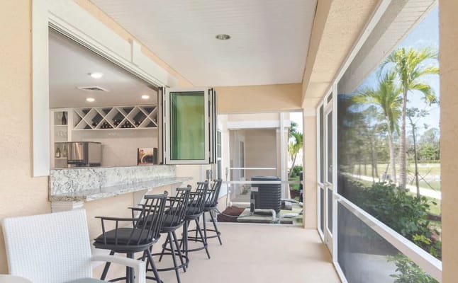 Outdoor seating area with bar and view of gardens