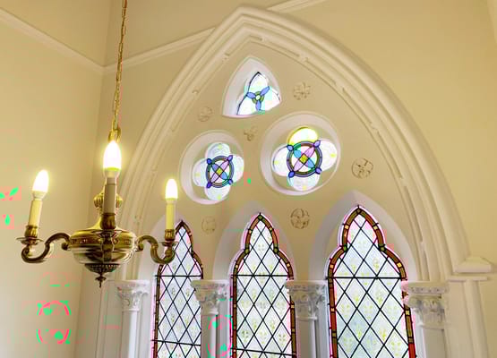 Interior view of stained glass windows and chandelier