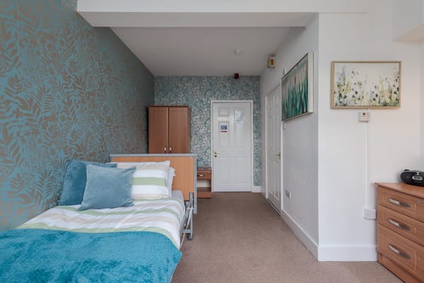 Interior of a private resident room with floral wallpaper
