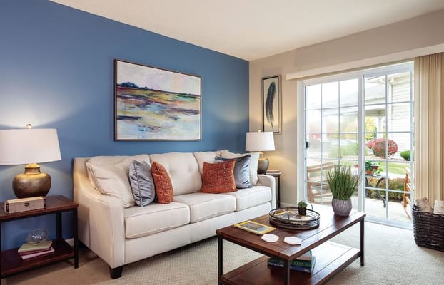 Living room with a comfortable sofa, artwork, and sliding glass door.