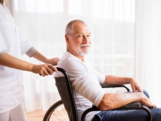 Caring staff assisting a senior in a wheelchair