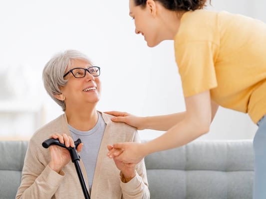 A senior woman smiling while interacting with staff