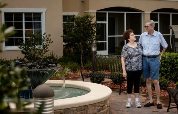 A couple enjoying time by a fountain in the garden