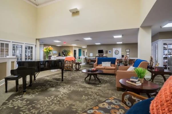 Bright common area with seating and a piano
