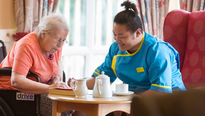 Staff member assisting a resident in a cozy interior