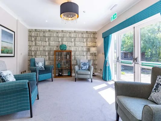A cozy common area in a care home with comfortable chairs